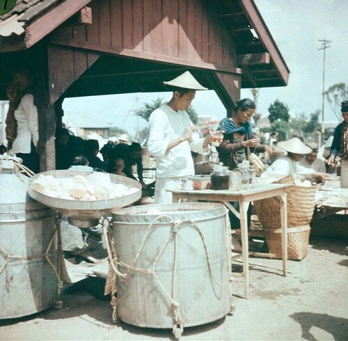 Market view in Tawangmangu, Karanganyar, Central Java circa 1930s - on the left are barrels with kerupuk, on the right a Chinese seller preparing a drink. Suasana Pasar di Tawangmangu, Karanganyar, Jawa Tengah tahun 1930an - di sebelah kiri ada blek berisi kerupuk, di sebelah kanan penjual Tionghoa sedang menyiapkan minuman.